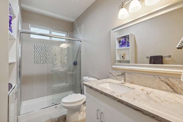 full bath featuring a stall shower, vanity, and toilet