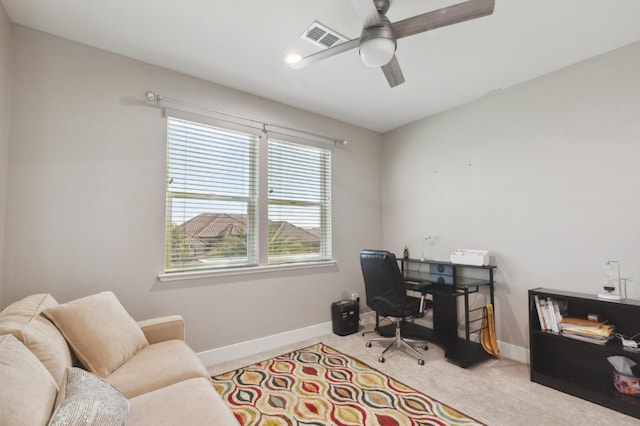 carpeted home office featuring a ceiling fan, visible vents, and baseboards