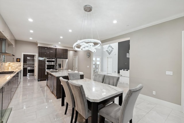 dining area with baseboards, a chandelier, crown molding, and recessed lighting