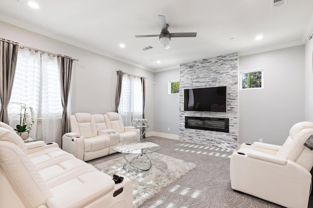 carpeted living area with a large fireplace, a healthy amount of sunlight, visible vents, and crown molding