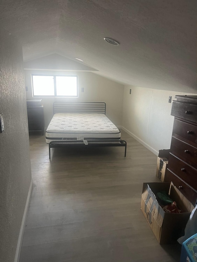 15245 El Mar Ln, Kerman, CA 93630 - bedroom featuring lofted ceiling, baseboards, wood finished floors, and a textured wall