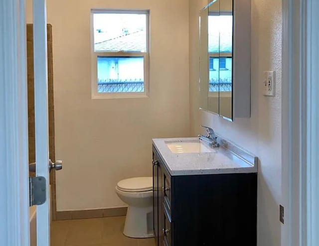 bathroom with toilet, tile patterned flooring, vanity, and baseboards