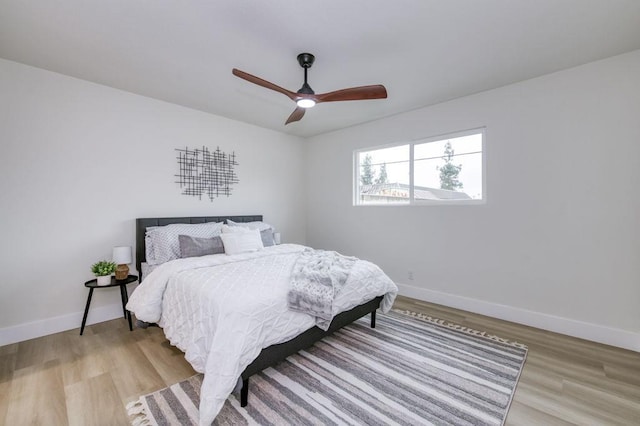 bedroom featuring light wood-style floors, ceiling fan, and baseboards