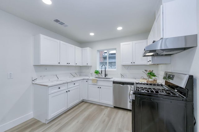 kitchen with under cabinet range hood, stainless steel appliances, a sink, visible vents, and light wood finished floors