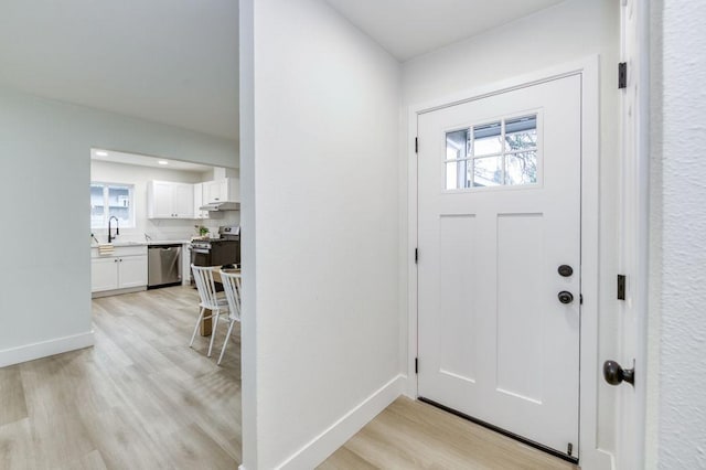 entrance foyer with light wood-style floors and baseboards