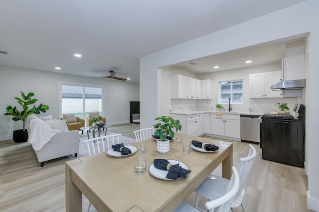 dining space with light wood-type flooring, recessed lighting, and baseboards