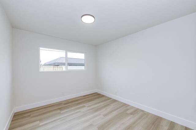 unfurnished room with light wood-style floors and baseboards