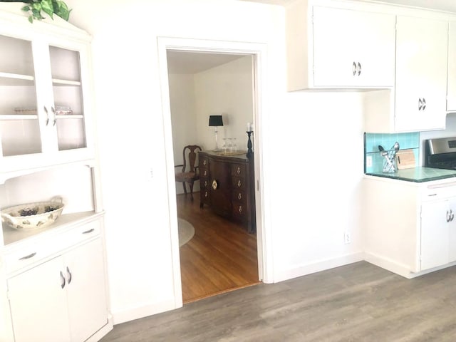 kitchen with light wood-style flooring, tasteful backsplash, white cabinets, and stainless steel gas range oven