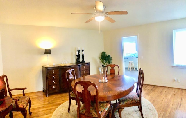 dining space with light wood-type flooring and a ceiling fan