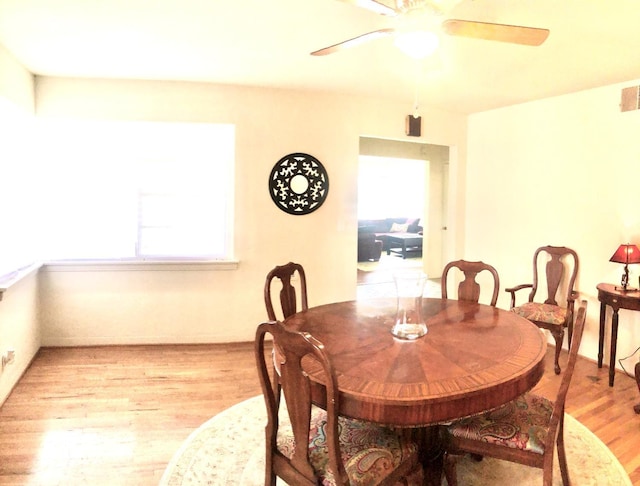 dining space with visible vents, light wood finished floors, and ceiling fan