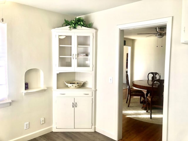 interior space with dark wood-style floors, baseboards, and ceiling fan