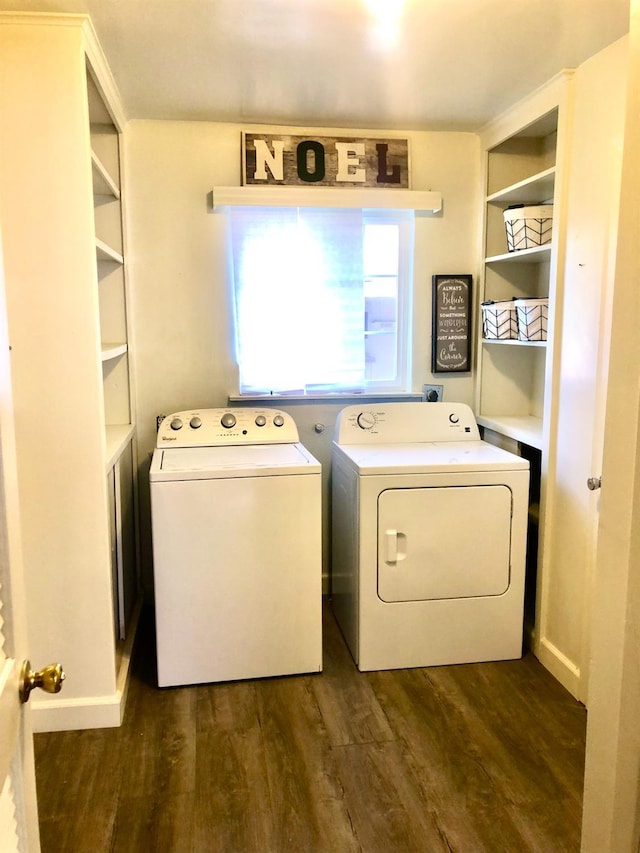 clothes washing area with dark wood-style flooring, washing machine and dryer, and laundry area