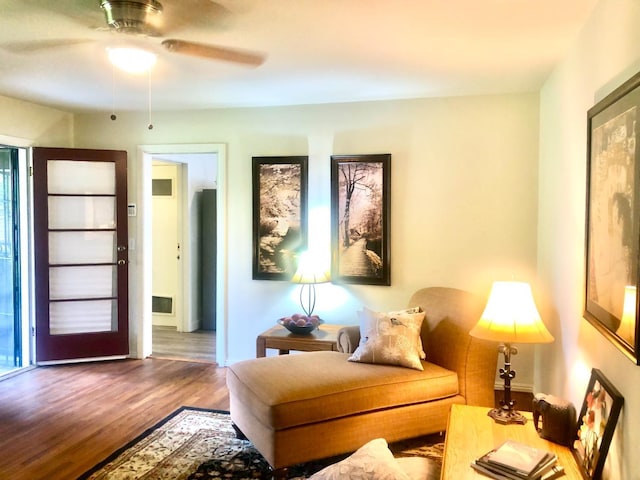 living area with a ceiling fan and wood finished floors