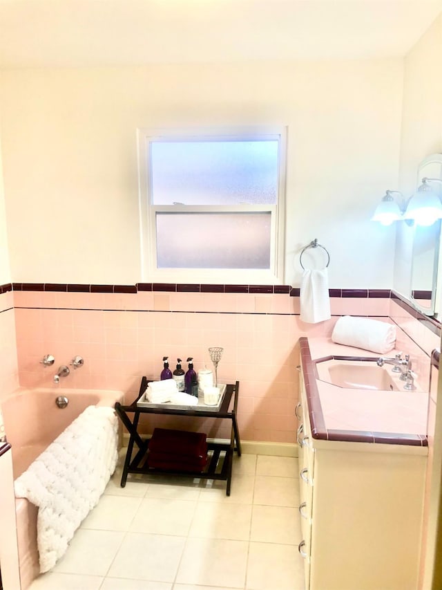 full bath with vanity, a garden tub, a wainscoted wall, tile patterned flooring, and tile walls