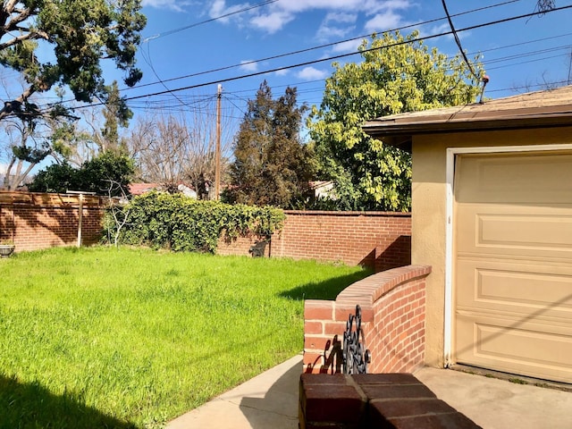 view of yard featuring a garage and fence