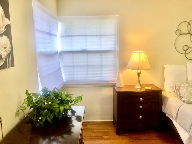 bedroom with baseboards and wood finished floors