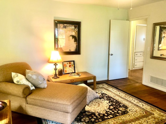 sitting room with visible vents, baseboards, and wood finished floors