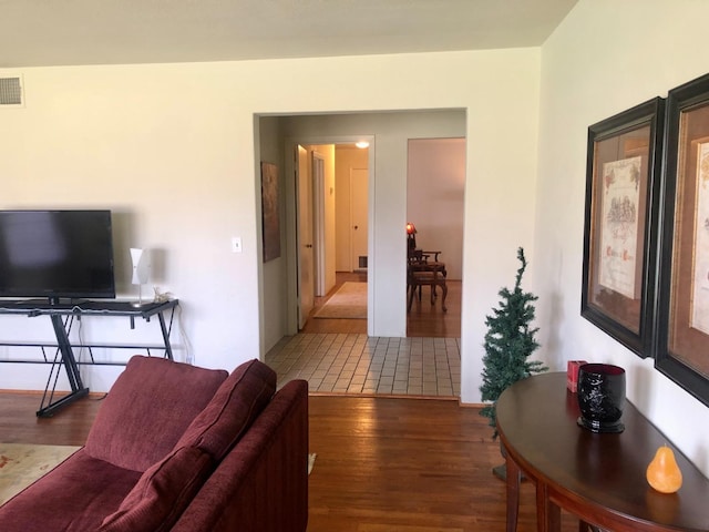 living area featuring visible vents and wood finished floors