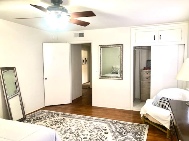 bedroom featuring ceiling fan, visible vents, a closet, and dark wood-style floors