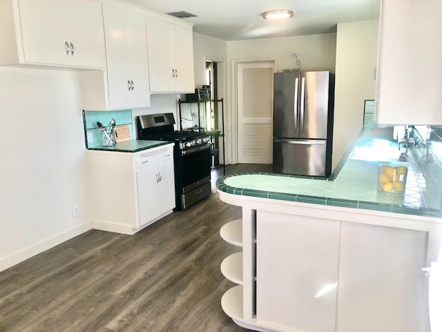 kitchen with visible vents, white cabinets, stainless steel appliances, and tile counters