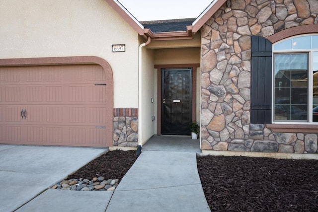 view of exterior entry featuring stone siding and stucco siding