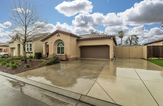 mediterranean / spanish home featuring a garage, driveway, a tile roof, and stucco siding