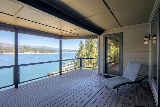 wooden deck with a water and mountain view