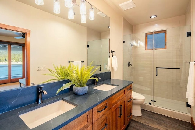 full bathroom with a sink, a shower stall, toilet, and wood finished floors