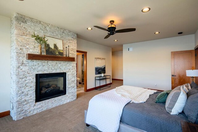 bedroom featuring ceiling fan, a stone fireplace, recessed lighting, carpet flooring, and baseboards