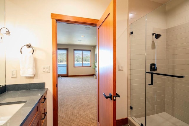 full bathroom with a stall shower, vanity, and baseboards