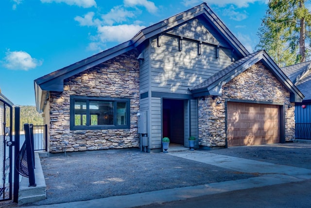 view of front of property with driveway, an attached garage, and fence