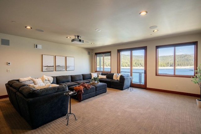 living area featuring recessed lighting, light colored carpet, plenty of natural light, and baseboards