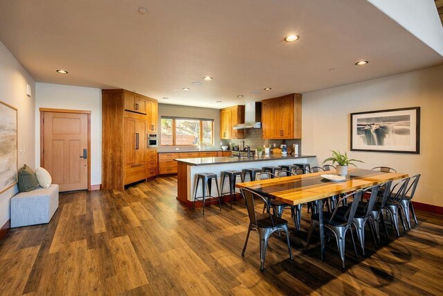 dining room featuring dark wood-type flooring, recessed lighting, and baseboards