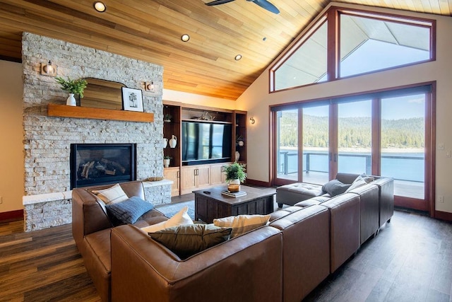 living area featuring baseboards, wood ceiling, wood finished floors, a stone fireplace, and high vaulted ceiling