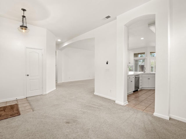 unfurnished room with recessed lighting, light colored carpet, visible vents, and arched walkways