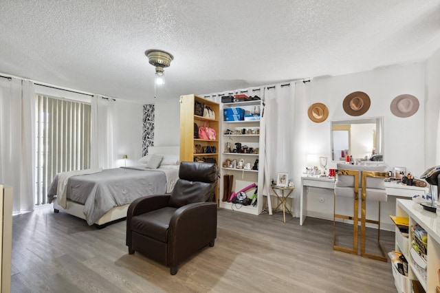 bedroom with a textured ceiling and light wood-style flooring