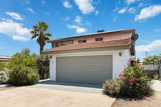 view of front of home with a garage, concrete driveway, and stucco siding