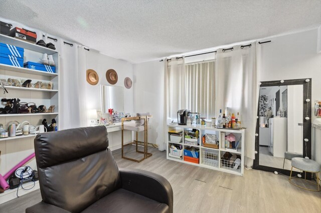 living area with a textured ceiling and wood finished floors