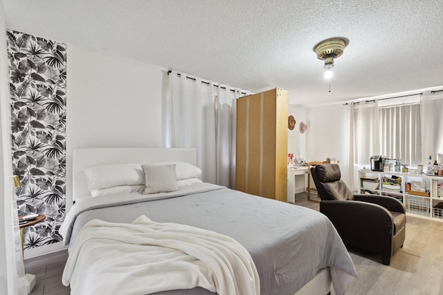 bedroom featuring a textured ceiling and wood finished floors