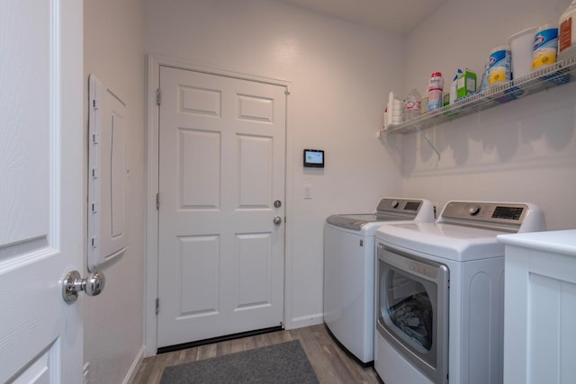 laundry room with dark wood-style floors, washer and clothes dryer, laundry area, electric panel, and baseboards