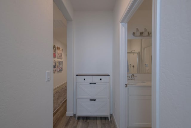 hallway with a sink and wood finished floors