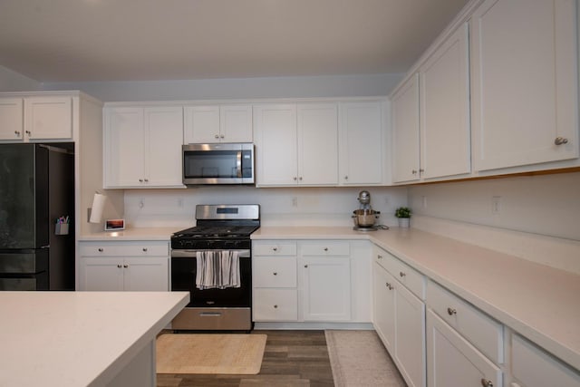 kitchen featuring white cabinets, dark wood finished floors, stainless steel appliances, and light countertops