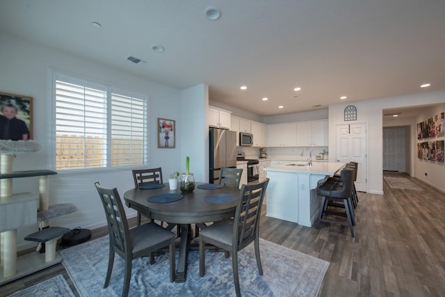 dining area with dark wood-type flooring, recessed lighting, visible vents, and baseboards