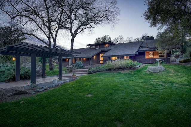 view of front facade featuring a patio area, a chimney, a front lawn, and a pergola