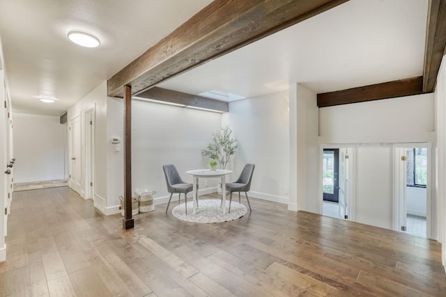 dining room with wood finished floors, beam ceiling, and baseboards