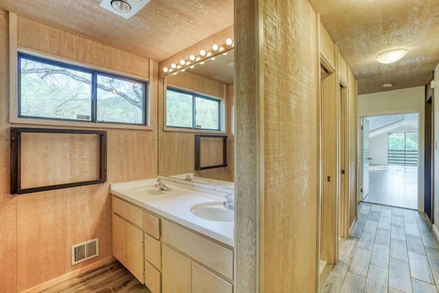 bathroom with double vanity, a sink, visible vents, and wood tiled floor