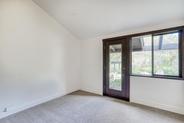 interior space with vaulted ceiling, carpet flooring, and baseboards