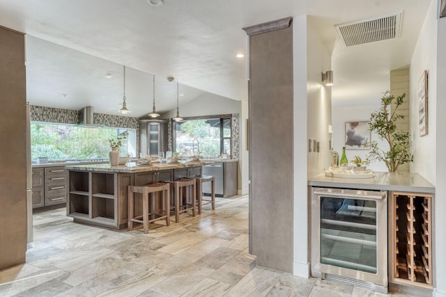 bar with lofted ceiling, visible vents, stainless steel dishwasher, wall chimney range hood, and beverage cooler