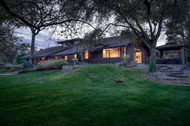 view of front of home featuring a front lawn, a jacuzzi, and a gazebo