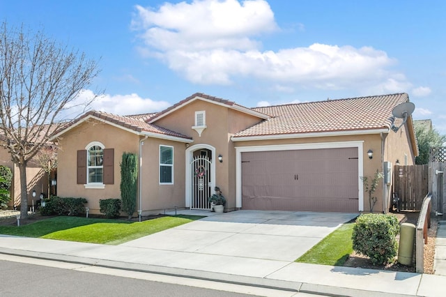 mediterranean / spanish-style house with driveway, a tiled roof, an attached garage, fence, and stucco siding